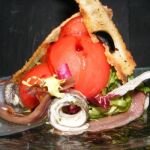 Ensalada matrimonio de boquerón y anchoas con huevo de codorniz y pan de olivas