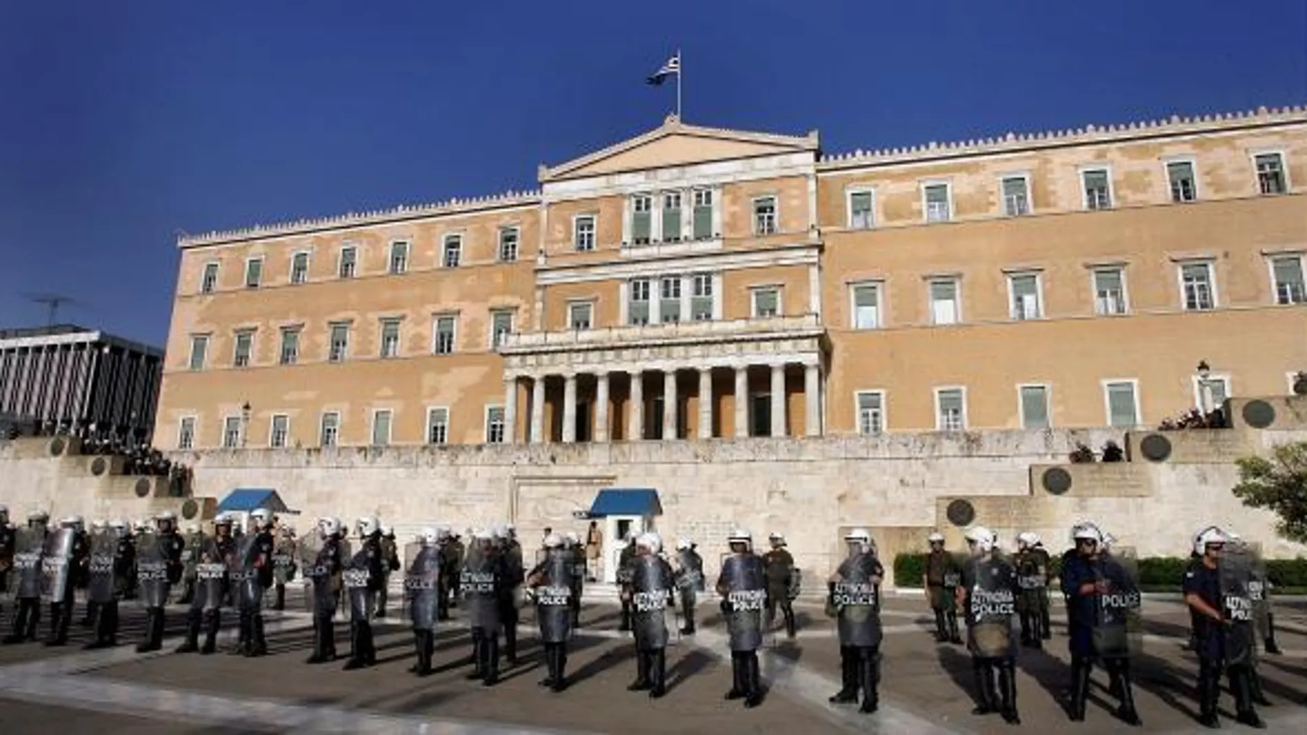 Policías antidisturbios vigilan a cientos de manifestantes que se congregan en el exterior del Parlamento de Atenas el pasado día 6