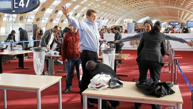 Agentes de seguridad cachean a pasajeros en el aeropuerto Charles De Gaulle de París en 2010