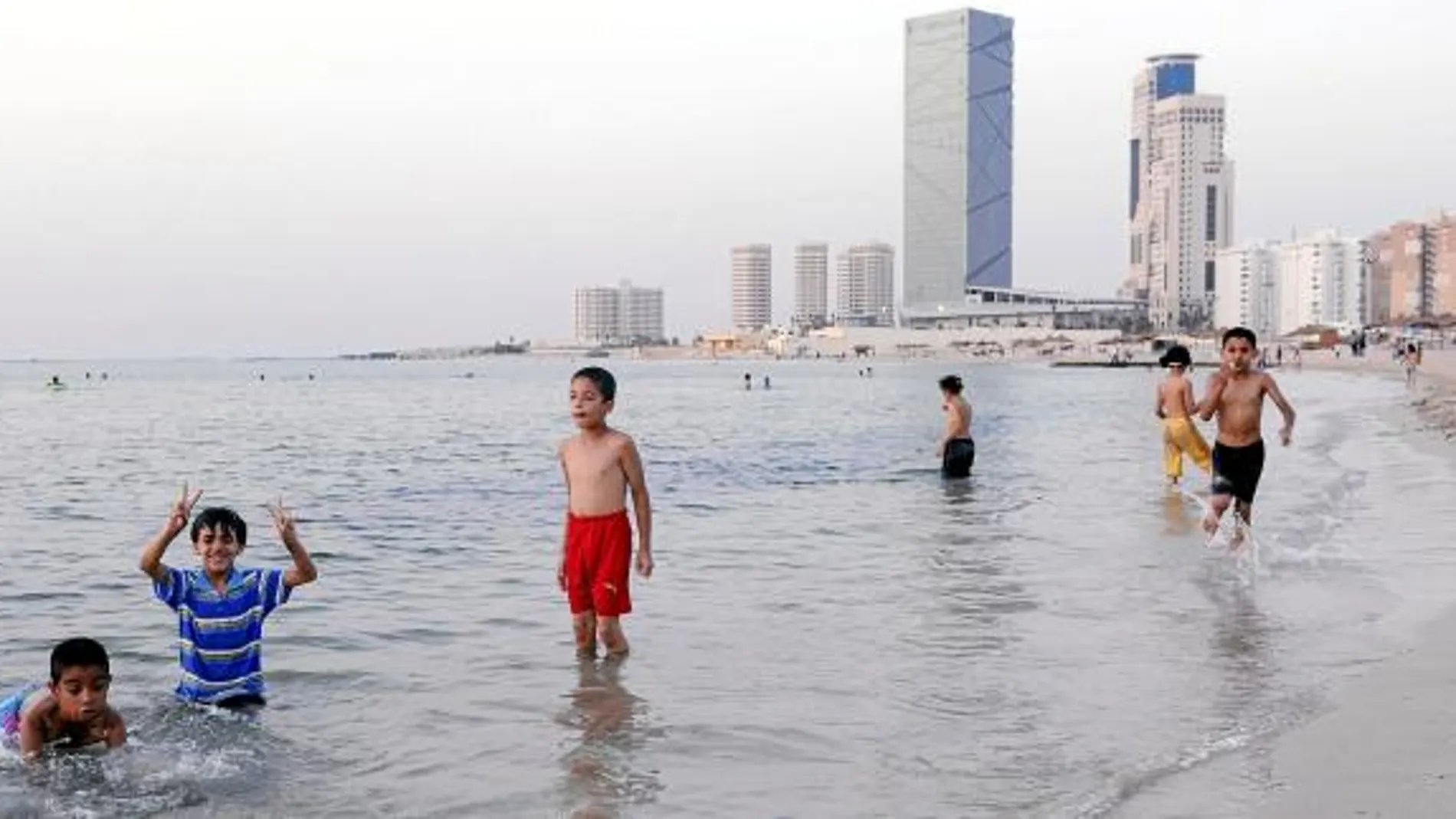 Unos niños se bañan en las playas de Trípoli