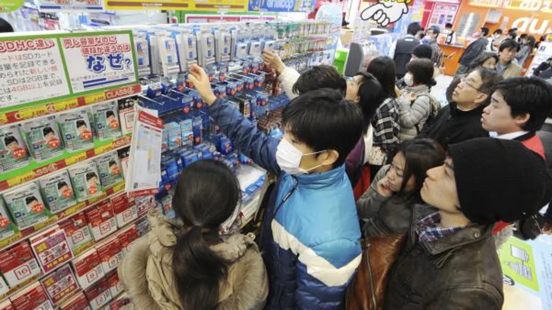 Clientes de un supermercado compran baterias mientras se preparan a los posibles cortes de luz en Tokio