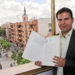 El candidato de Uleg, Carlos Delgado, posa con el acta notarial que firmó en campaña dando fe pública de que se votaría a sí mismo en la sesión de investidura