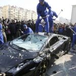 Los operarios destrozando el Lamborghini Gallardo (Foto: AP)