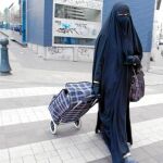 En la imagen, una mujer pasea por la vía pública ataviada con un burka