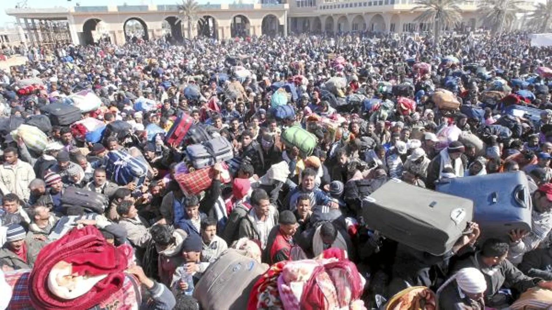CRISIS HUMANITARIA. Refugiados egipcios esperan en la frontera tunecina de Ras el Jebir