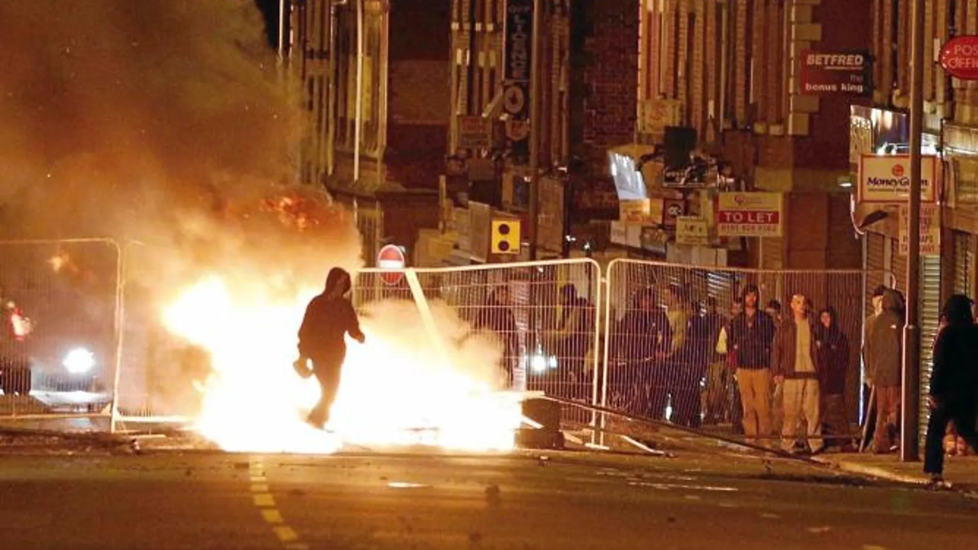 Un hombre camina junto a una barricada en Liverpool a primera hora de ayer