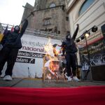 Dos encapuchados queman una foto del Rey (Foto: Miquel González)