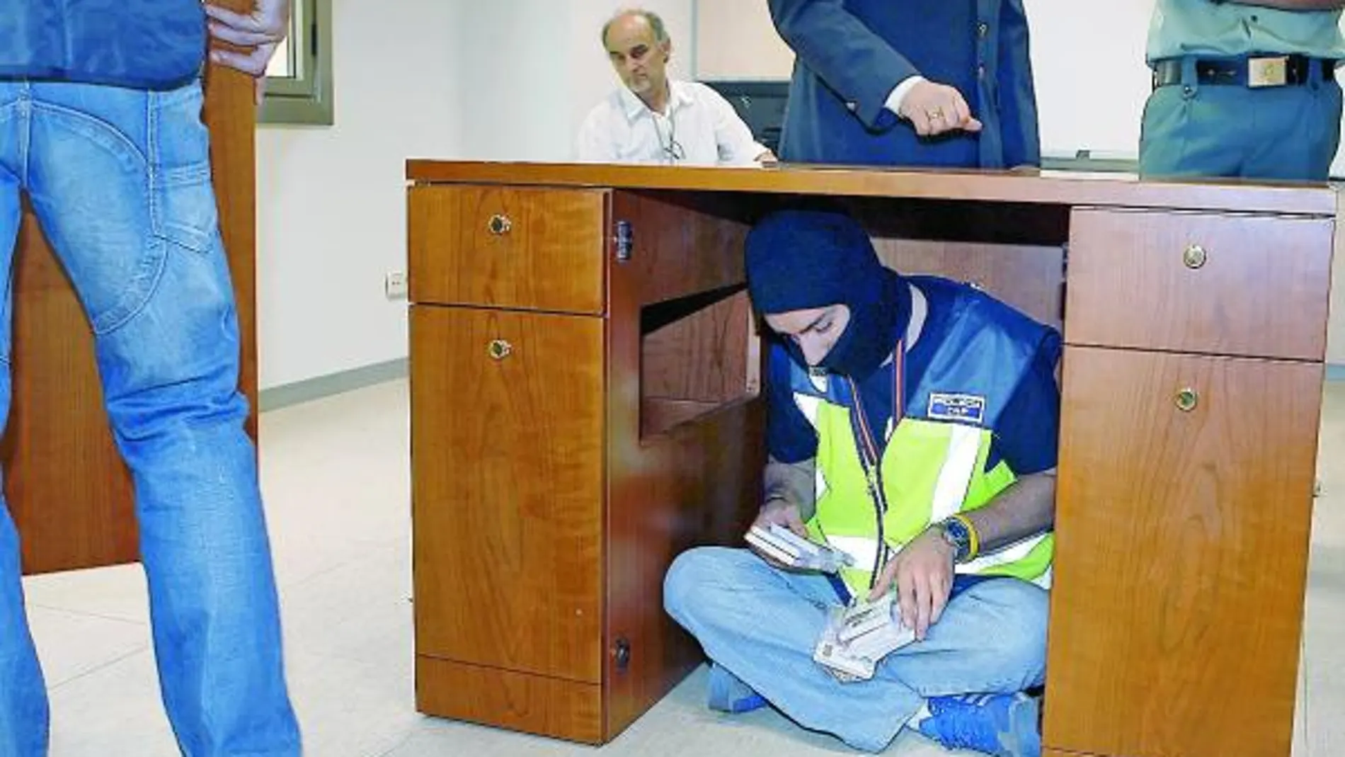 Un policía cuenta el dinero debajo del escritorio, como hicieron los timadores