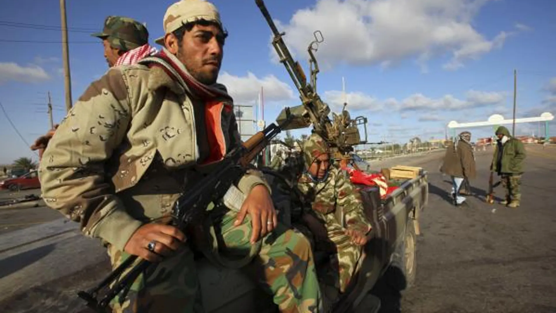 Miembros armados de las fuerzas rebeldes toman posiciones junto a una batería antiaérea cerca de Ras Lanuf, Libia