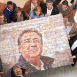 Los responsables distritales del PP recibieron a Zoido con un mural realizado con sus fotos de visitas a los barrios en el último lustro