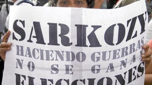 Una manifestante en Venezuela sujeta una pancarta contra el presidente francés, Nicolas Sarkozy