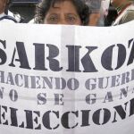 Una manifestante en Venezuela sujeta una pancarta contra el presidente francés, Nicolas Sarkozy