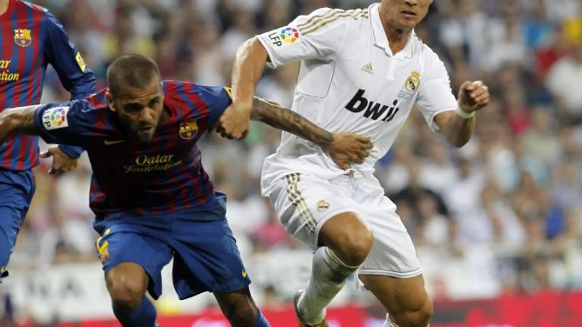 Dani Alves lucha por el balón con Cristiano Ronaldo en un Clásico.