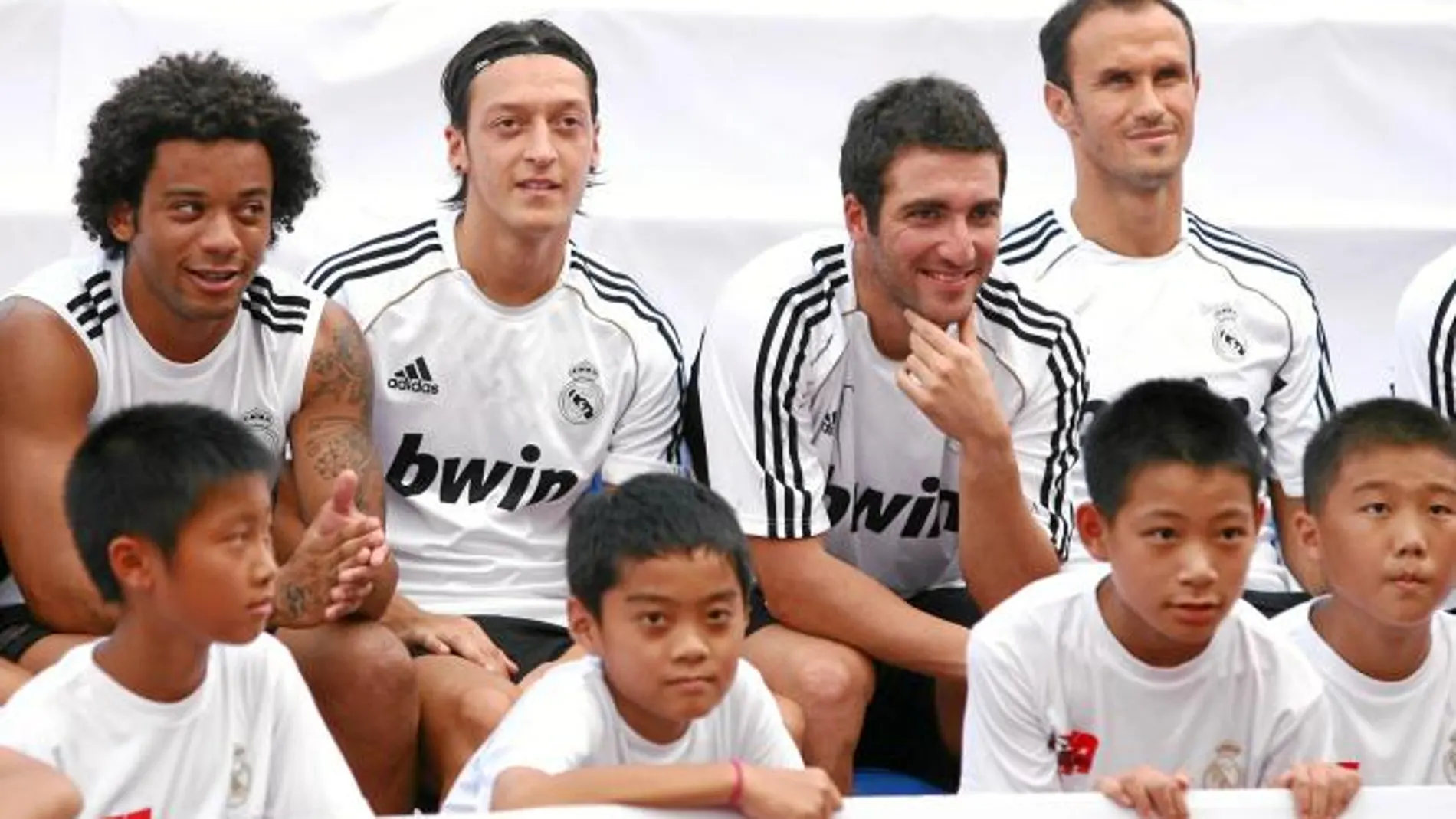 Marcelo, Özil, Higuaín y Carvalho junto a varios niños