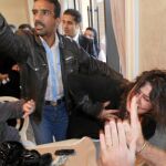 Un agente de Gadafi sujeta a una mujer que denunciaba su arresto y violación