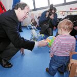 El presidente Herrera ofrece un balón a un pequeño, en la nueva escuela pública infantil del Condado de Treviño