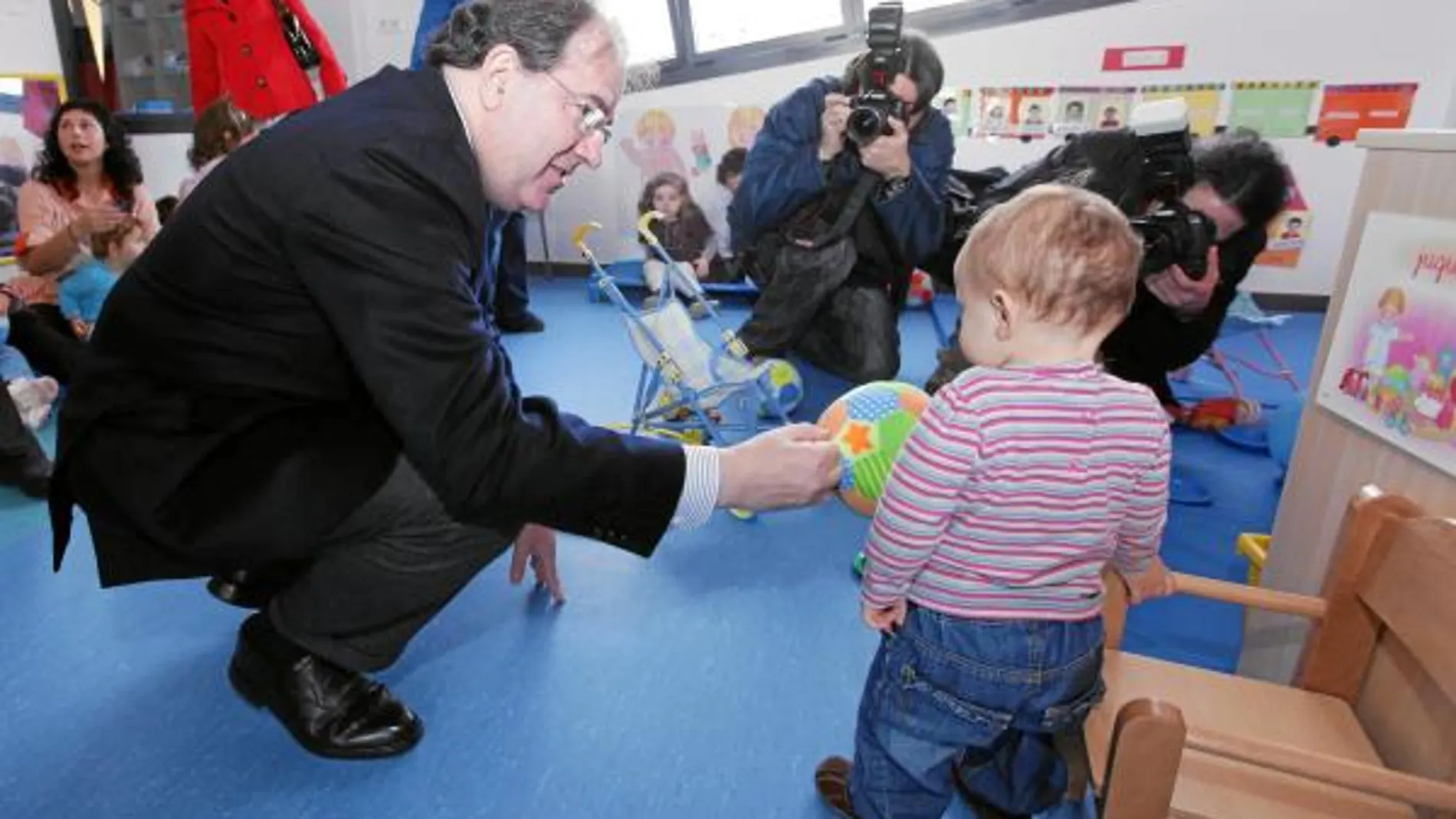 El presidente Herrera ofrece un balón a un pequeño, en la nueva escuela pública infantil del Condado de Treviño
