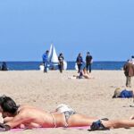 Varias personas toman el sol en la playa de Las Arenas de Valencia
