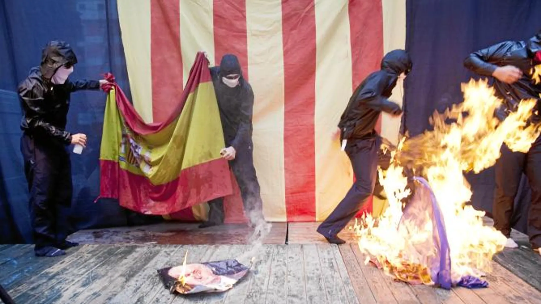 Un grupo de radicales encapuchados aprovechó ayer la celebración de la Diada para quemar las banderas de España y Francia, y una fotografía del Rey.