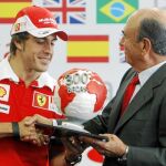 Fernando Alonso y el presidente de la entidad, Emilio Botín, asistieron al acto de entrega de 100 becas de movilidad internacional «Fórmula Santander», celebrado en el «paddock» del circuito de Valencia.
