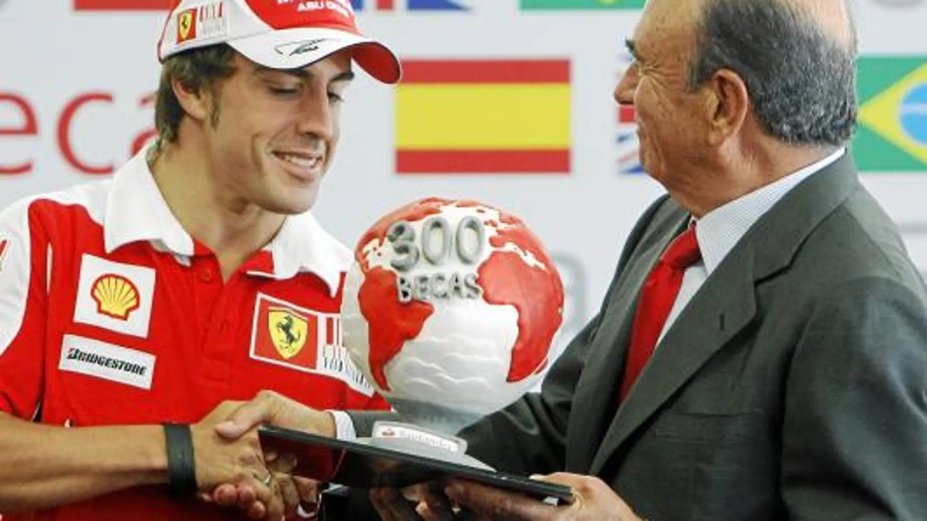 Fernando Alonso y el presidente de la entidad, Emilio Botín, asistieron al acto de entrega de 100 becas de movilidad internacional «Fórmula Santander», celebrado en el «paddock» del circuito de Valencia.