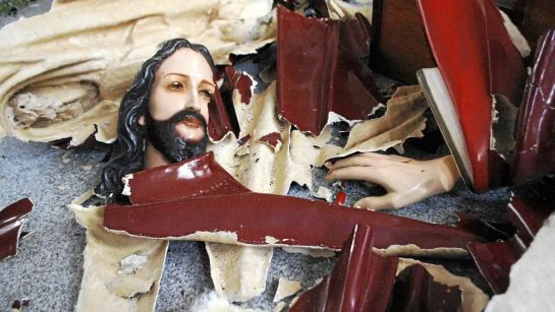 Los atacantes destrozaron mobiliario e imágenes como la de este Cristo durante el asalto