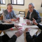 Cuatro jubilados juegan una partida de cartas en un centro para pensionista en Segovia