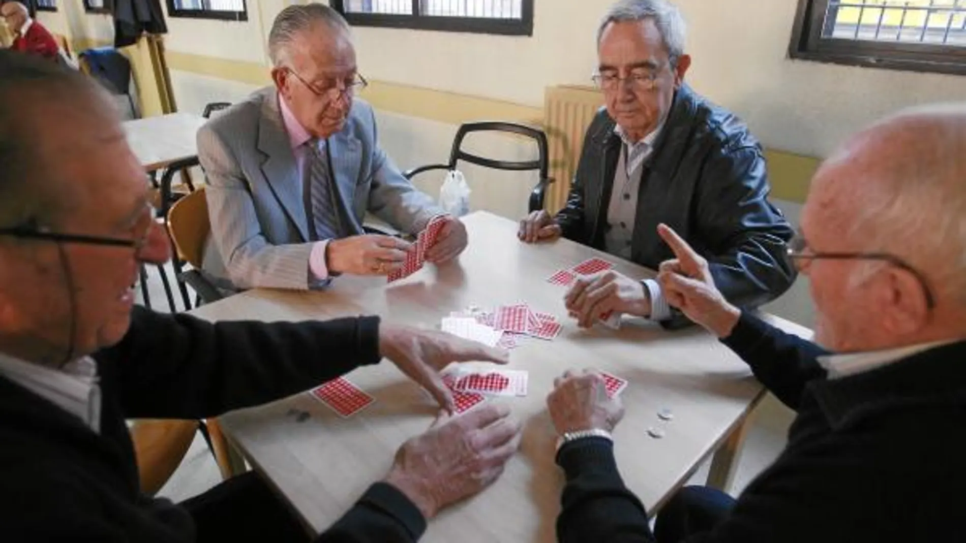 Cuatro jubilados juegan una partida de cartas en un centro para pensionista en Segovia