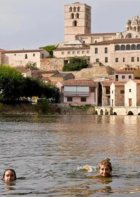 Dos mujeres se bañan, en las aguas del río Duero a su paso por Zamora, para calmar el calor de la jornada de ayer