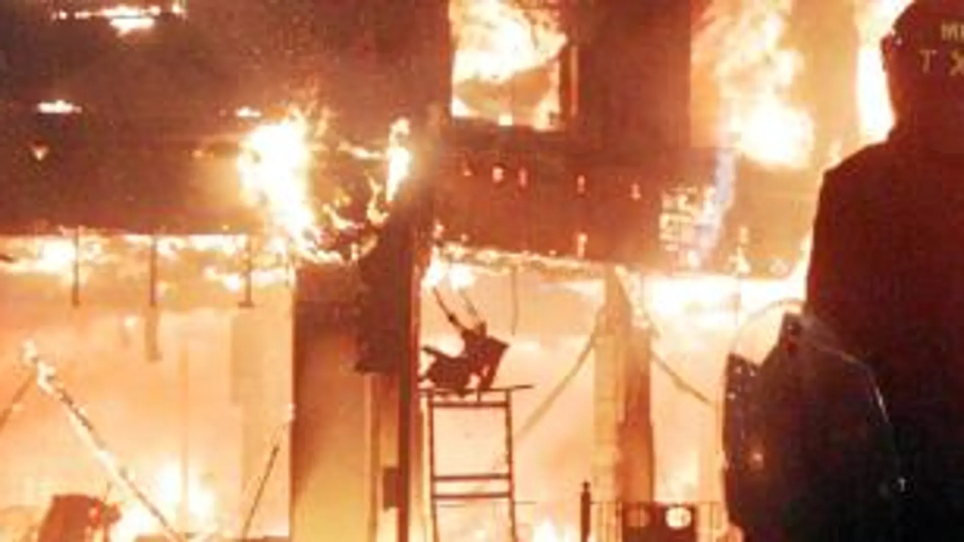 Un antidisturbios observa un edificio en llamas del barrio de Tottenham, ayer