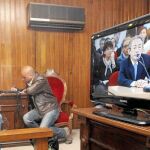 Dos periodistas toman nota mientras siguen la declaración de Ángel Luna en un monitor