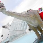 Una figura de la exposición «Entre dinosaurios», con adornos navideños