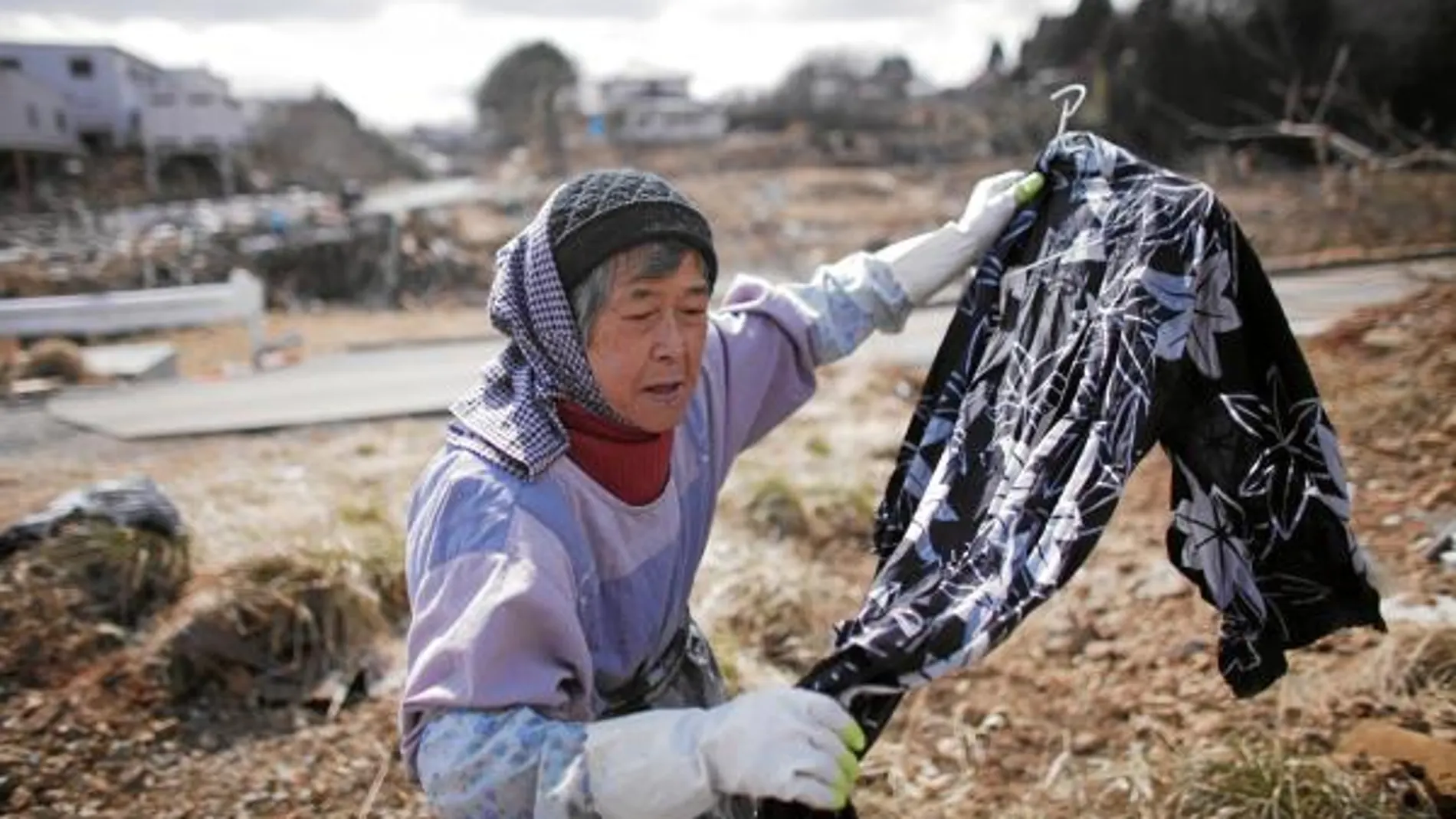 Una anciana recoge sus pertenencias en una de las zonas afectadas por la radiactividad