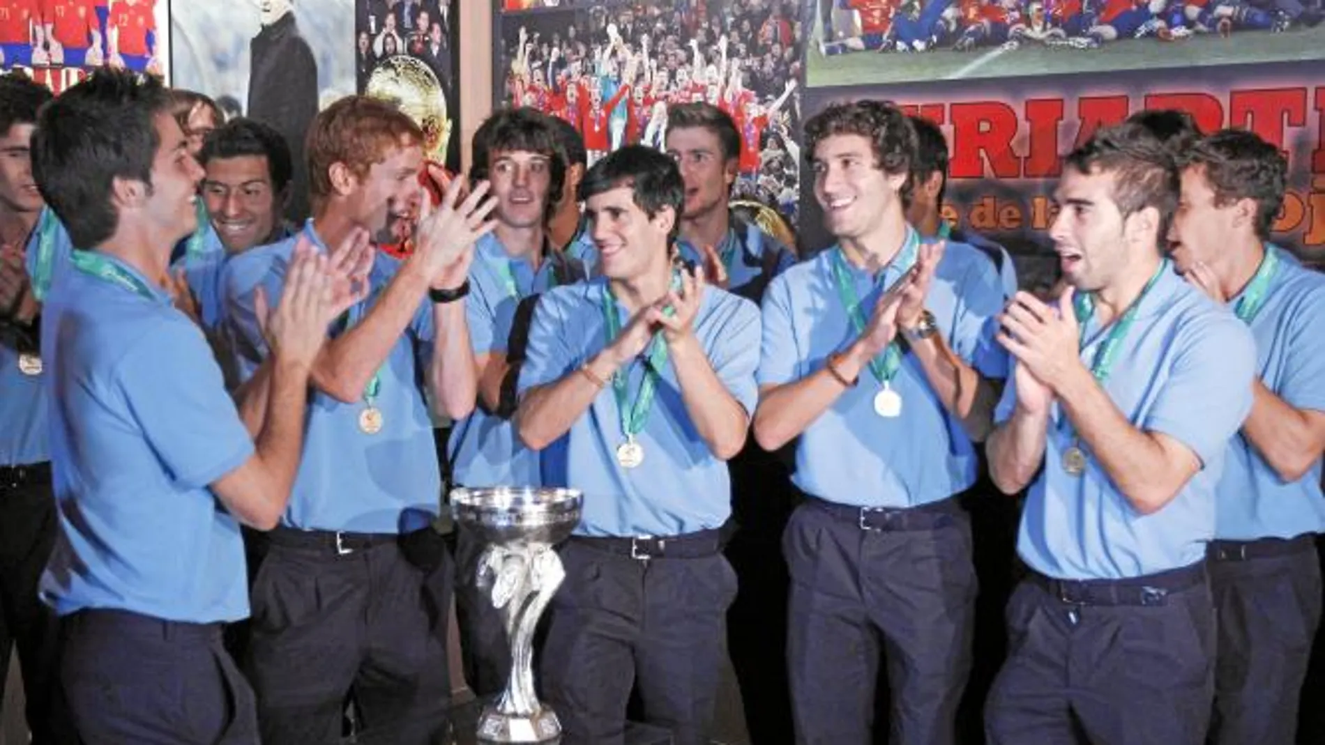 Los campeones palmean y cantan mientras posan con el trofeo