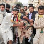 Manifestantes antigubernamentales trasladan a uno de los heridos, ayer, durante las protestas en Saná