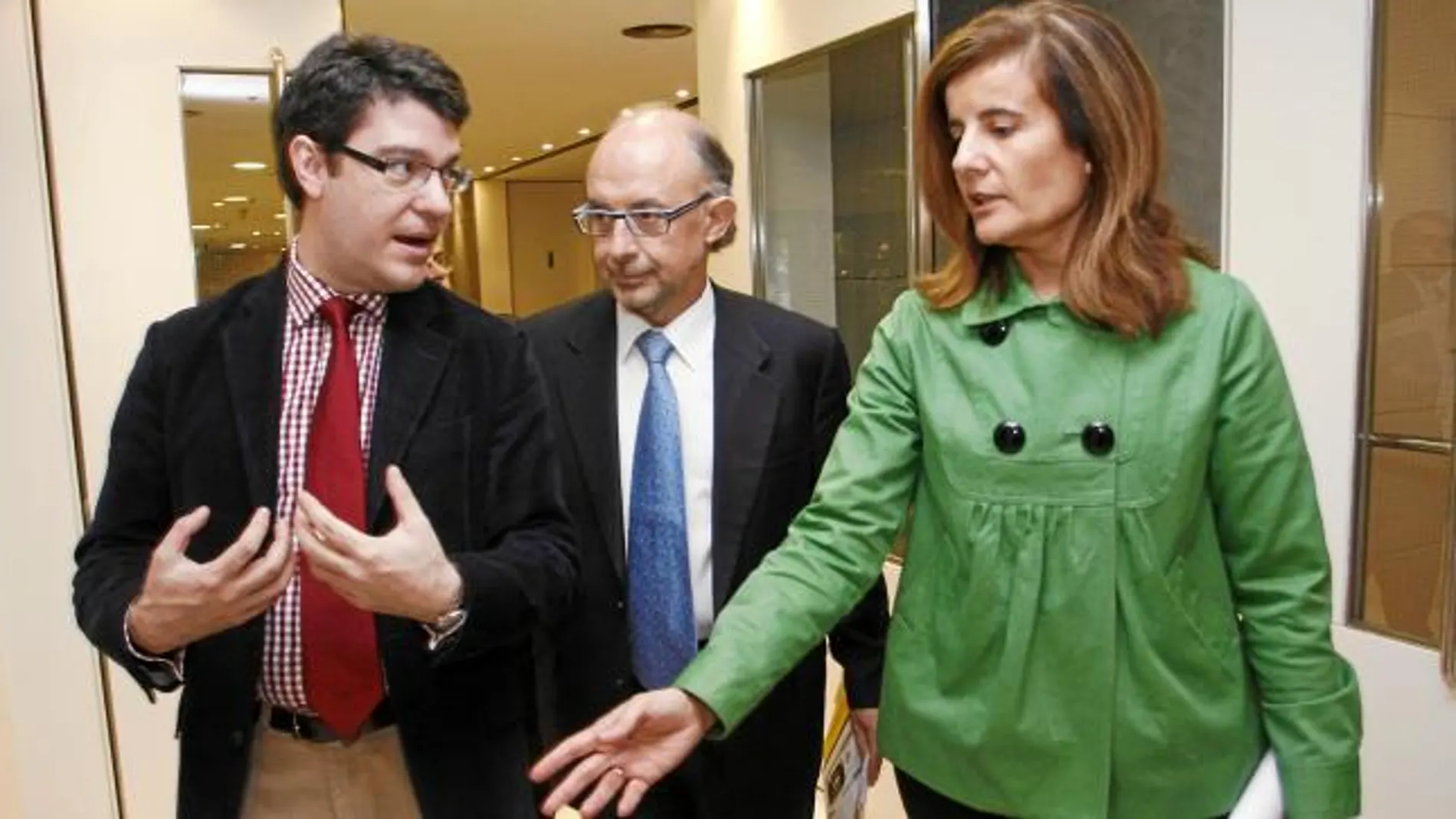 EL equipo económico de Rajoy: Álvaro Nadal, a la izquierda, conversa en los pasillos del Congreso de los Diputados con Cristóbal Montoro (ministro de Hacienda) y Fátima Báñez (ministra de Empleo)