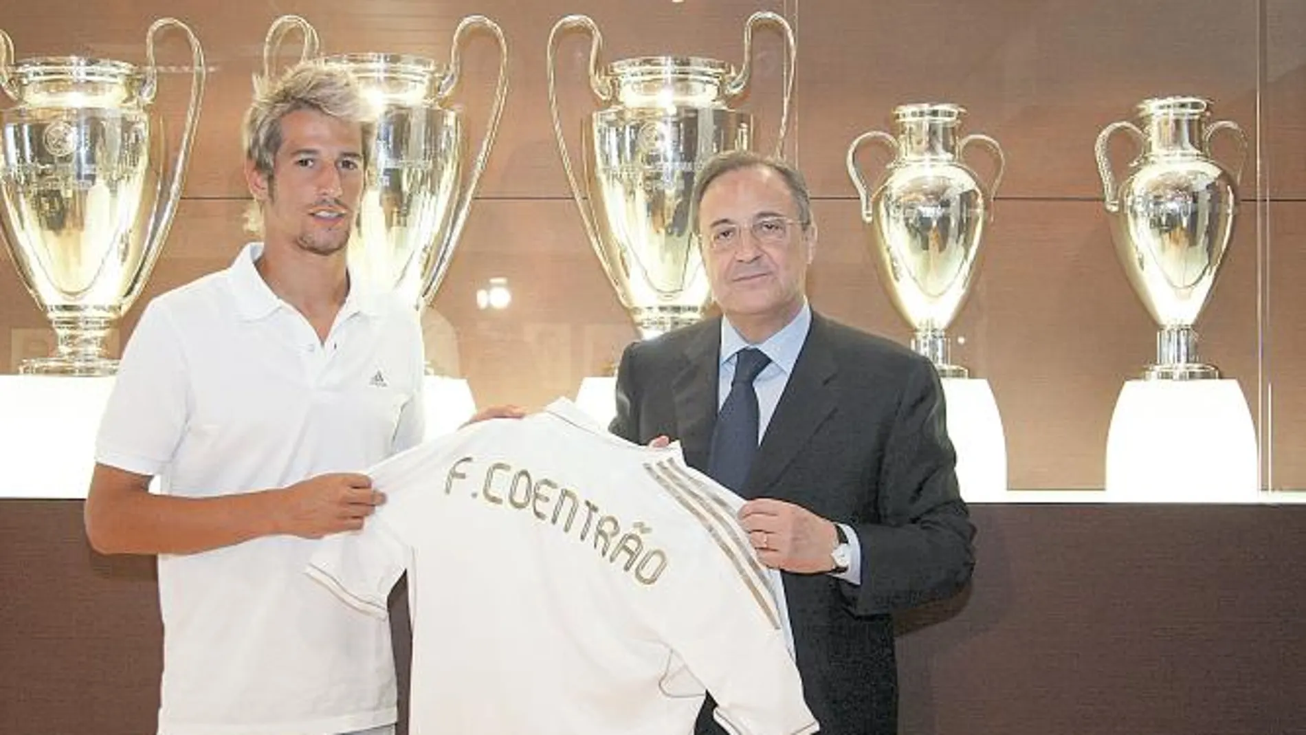 Coentrao enseña su nueva camiseta al lado de Florentino Pérez, en la sala de trofeos del Santiago Bernabéu