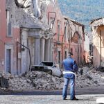 Un policía observa las ruinas de los edificios después del terremoto en L'Aquila en 2009