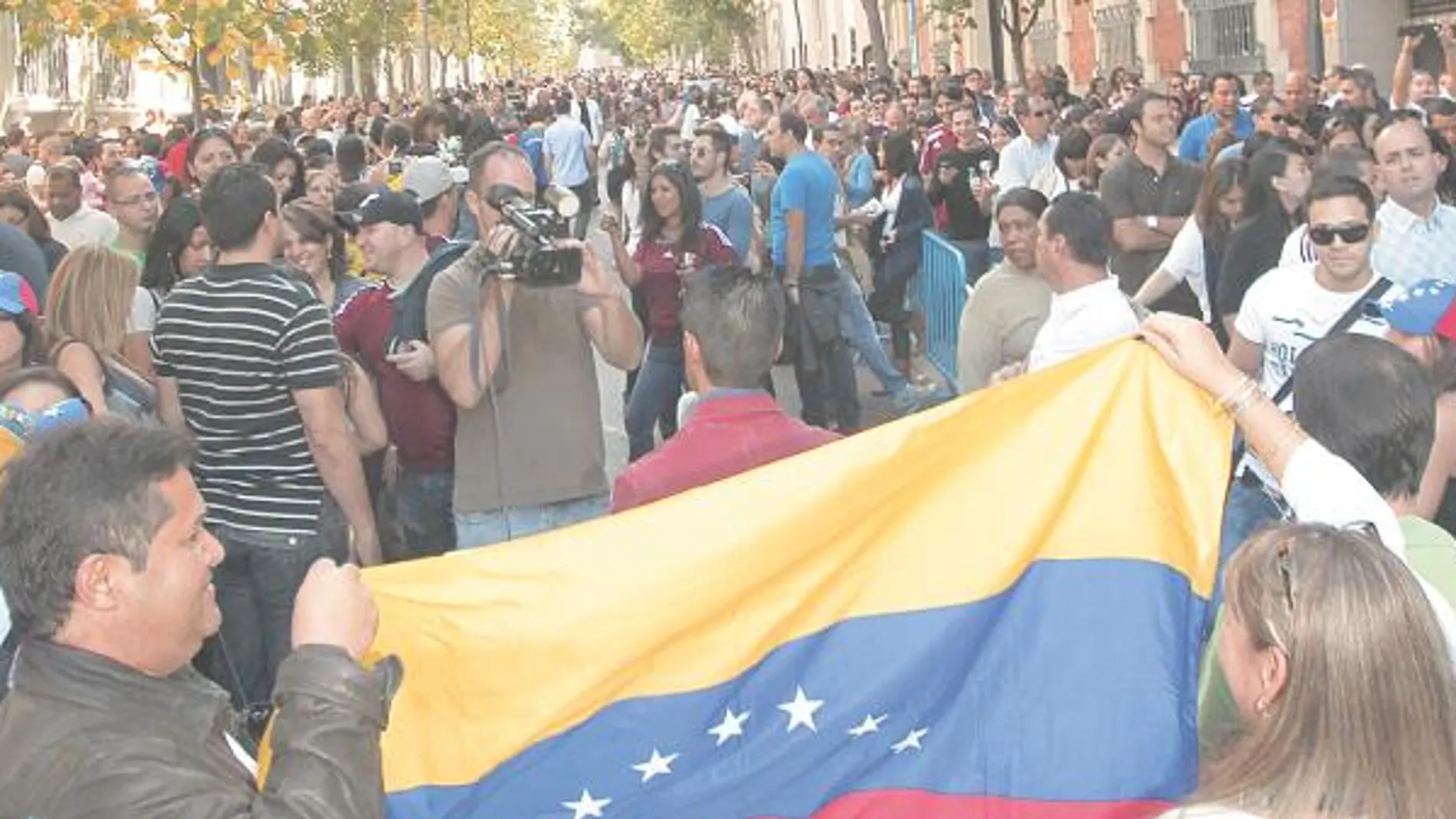 BANDERAS Y GORRAS TRICOLOR. Los símbolos venezolanos se dejaban ver en la larga fila para votar, que llegaba de Recoletos a la Puerta de Alcalá