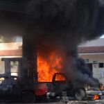 Vista de dos vehículos quemados al interior de una estación de gasolina, en la ciudad de Puerto Vallarta, estado de Jalisco (México).