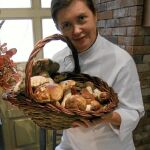 La cocinera muestra una cesta de setas que han llegado a su restaurante, La cocina de María Luisa