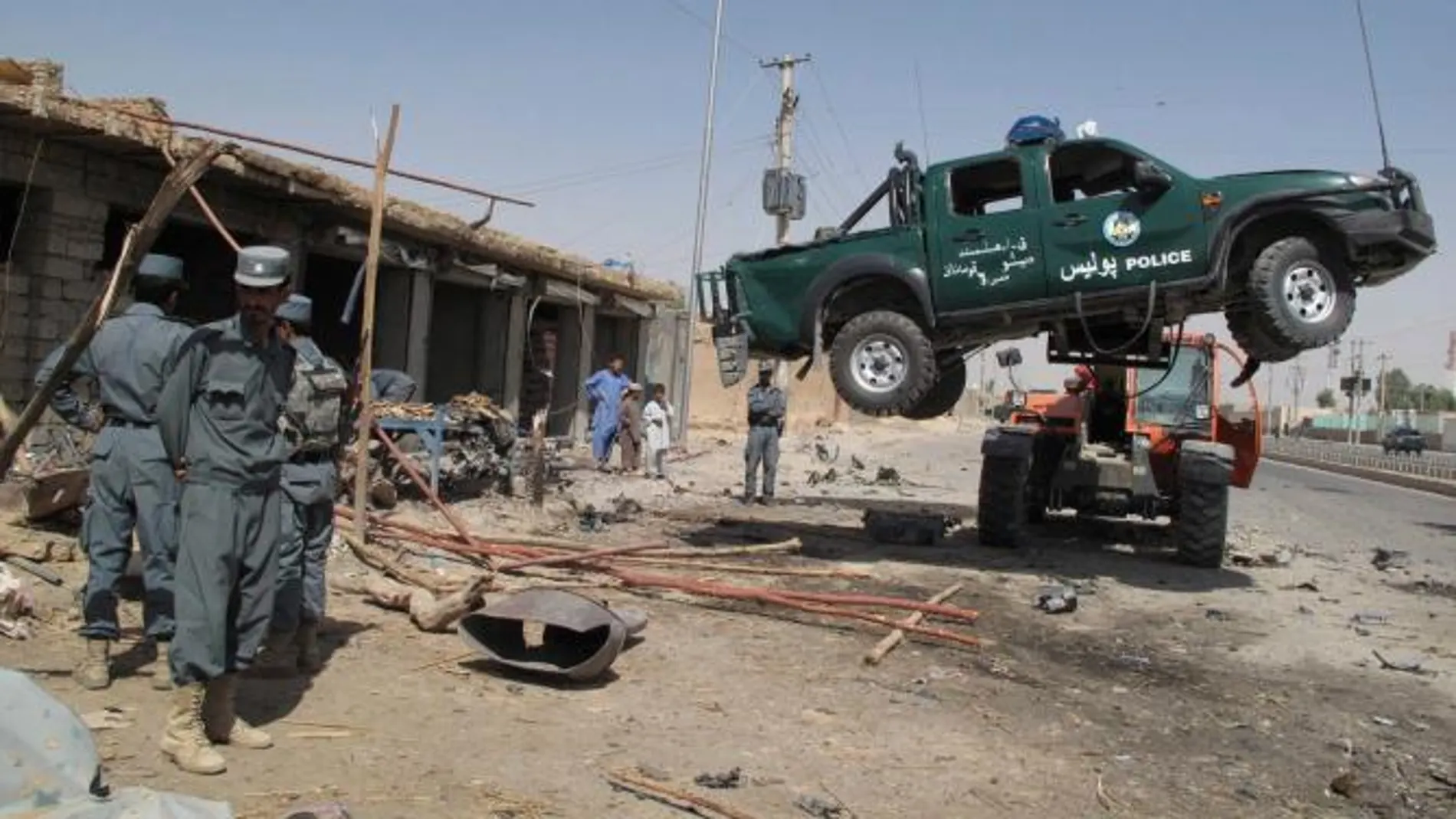 Policías inspeccionan la escena donde explotó ayer un carro bomba en Lashkar Gag, Afganistán