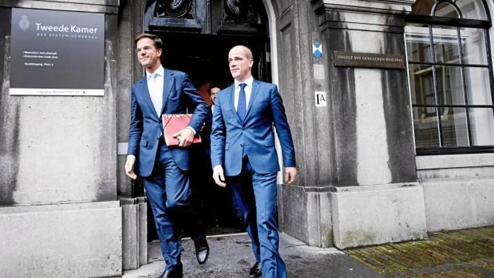 El «premier» holandés, Mark Rutte, (izda.) y el líder socialdemócrata, Diederik Samsom, salen del Parlamento en La Haya