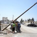 Miembros del ELS intentan levantar un poste de tendido eléctrico cerca de Alepo