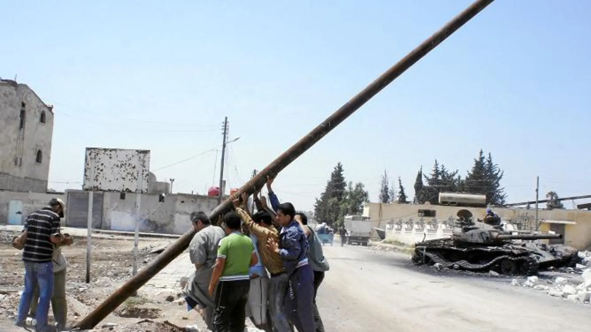 Miembros del ELS intentan levantar un poste de tendido eléctrico cerca de Alepo