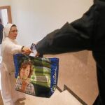 Una de las religiosas entrega alimentos para una familia del barrio de Vallecas
