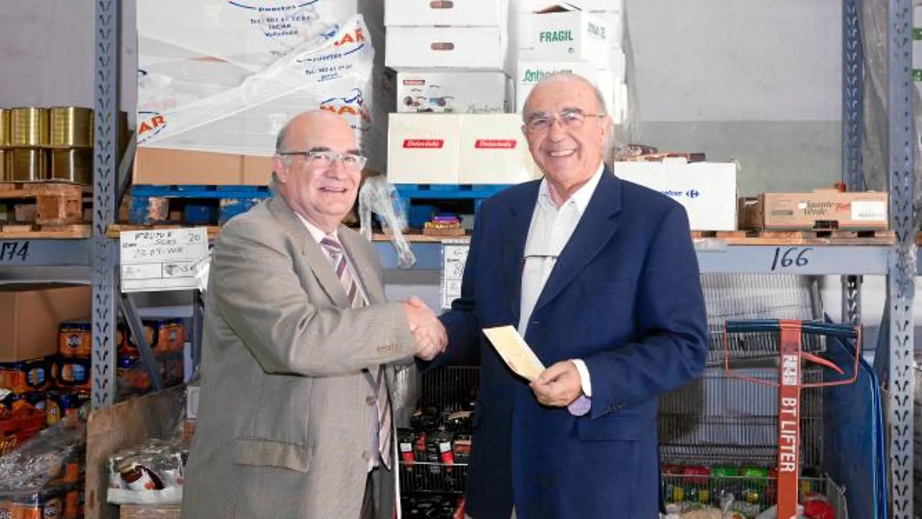 Javier Ojeda hace entrega del cheque a José María Zárate en la sede de Banco de Alimentos de Valladolid