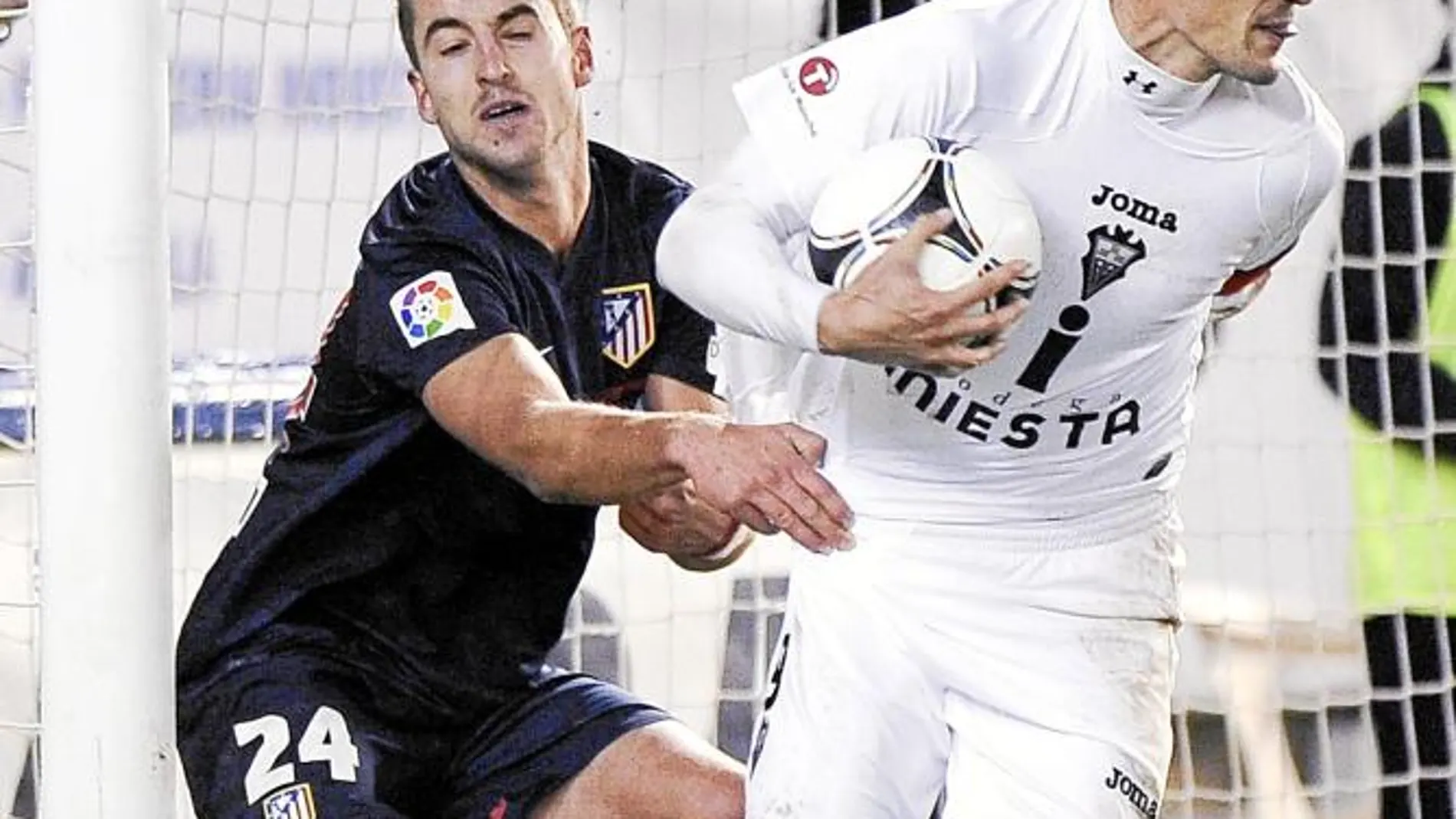 Calle, con el balón en la mano tras marcar un gol de penalti mientras el defensa del Atlético Pulido trata de agarrarlo
