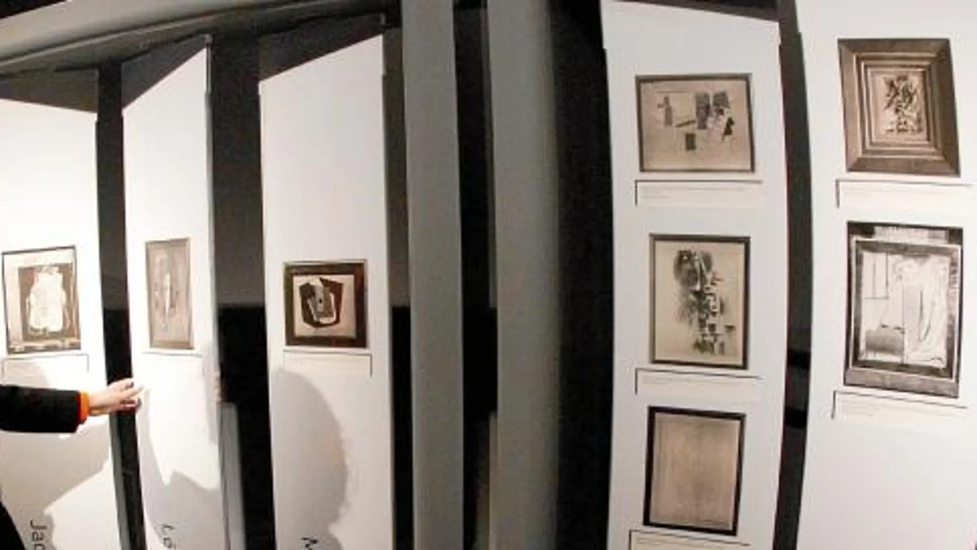 Una visitante de la muestra contempla las fotografías de las piezas que se expusieron en 1936