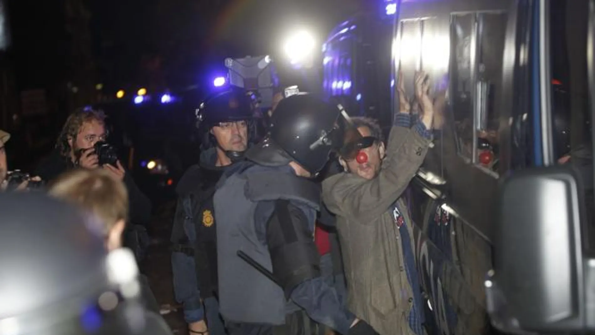 Uno de los concentrados se encara con la policía portando una nariz de payaso